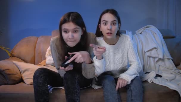 Deux filles heureuses excitées jouant à des jeux vidéo sur la console et s'amusant la nuit — Video