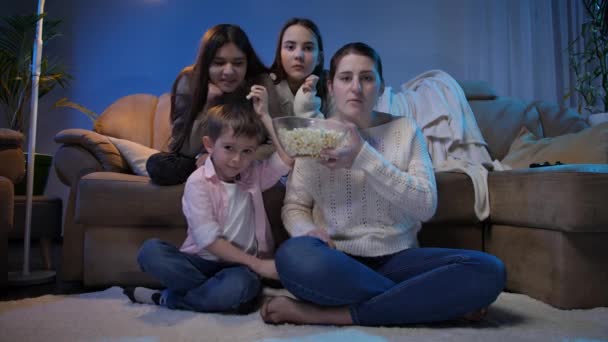 Grande família assistindo tarde da noite programa de TV e comer pipocas na sala de estar — Vídeo de Stock