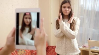 İnternete yüklemek için dans eden genç bir kızın akıllı telefonuyla ya da tabletle video kaydediliyor. Modern iletişim, sosyal medya ve aygıtlar
