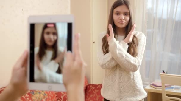 İnternete yüklemek için dans eden genç bir kızın akıllı telefonuyla ya da tabletle video kaydediliyor. Modern iletişim, sosyal medya ve aygıtlar — Stok video