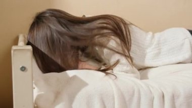 Yatakta yastığa düşüp ağlayan üzgün genç kız. Gençlik depresyonu ve sosyal sorunlar