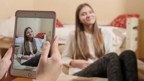 Menina adolescente bonita posando para fotografias em mídias sociais em casa. Comunicação moderna, mídias sociais e gadgets — Vídeo de Stock