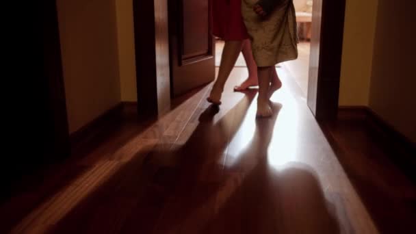 Family members in towels and bathrobes walking from bedroom to bathroom or swimming pool at morning. Concept of family living in big house or on vacation — Stock Video