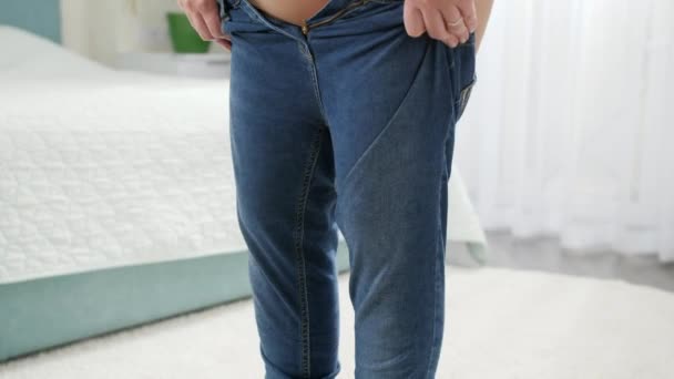 Jeune femme portant des jeans serrés et ne parvient pas à les attacher. Notion de poids excessif, d'obésité féminine, de régime alimentaire et de problèmes d'embonpoint — Video