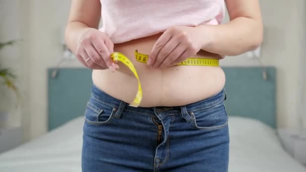 測定テープで腰を測定する重量を減らすことを考える若い女性。ダイエットの概念,不健康なライフスタイル,太りすぎと肥満 — ストック動画