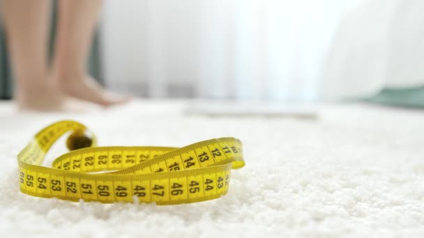 Female feet walking and standing on weights in bedroom. Concept of dieting, loosing weight and healthy lifestyle. — Stock Video