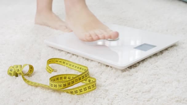 Barefoot woman standing on digital scales. Concept of dieting, loosing weight and healthy lifestyle. — Stock Video