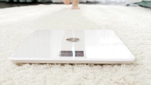 Ztráta bosé ženy stojící na digitálních váhách na bílém koberci v ložnici. Koncepce stravy, hubnutí a zdravého životního stylu. — Stock video