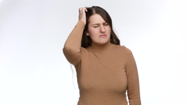 Studio portrait of thoughtful young woman scrubbing her head and thinking. Doubts and frustration — Stock Video