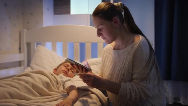 Junge besorgte Mutter telefoniert nachts mit Arzt. Konzept der Kinderkrankheit und der elterlichen Betreuung — Stockvideo