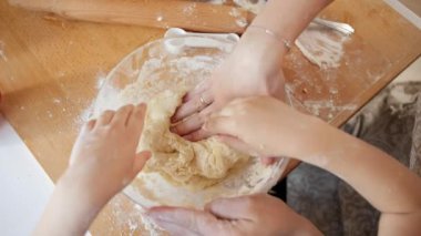 Annesinin büyük cam kasede bisküvi hamuru yoğurduğu küçük çocuğun yakın çekimi. Çocuklar aileleriyle yemek pişirir, küçük aşçı olur, aile birlikte vakit geçirir, ev mutfağı olur..