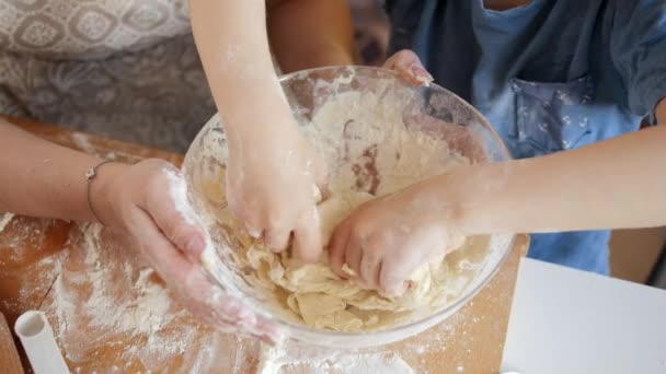 Egy kisfiúról, aki tésztát kevert egy nagy üvegtálba. Gyerekek főzés a szülőkkel, kis szakács, családi együttlét, háztartási konyha. — Stock videók