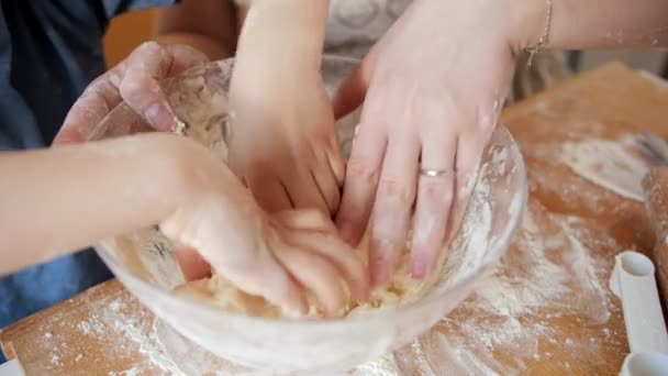 Close-up van moeders en kinderen handen kneden deeg ingrediënten in glazen kom tijdens het maken van koekjes. Kinderen koken met ouders, kleine chef-kok, familie hebben tijd samen, huishoudelijke keuken. — Stockvideo