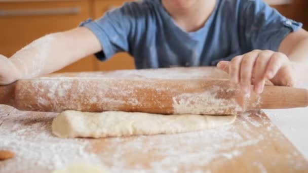 Närbild av liten pojke rullande deg med rullande stift för att göra pizza. — Stockvideo