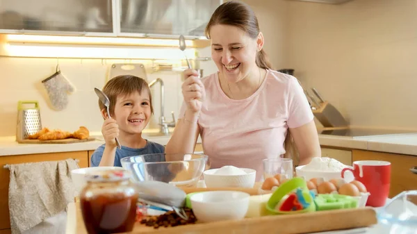 Ragazzino con madre che guarda gli ingredienti per cucinare gustoso piatto. Bambini che cucinano con i genitori, piccolo chef, famiglia che ha tempo insieme, cucina domestica. — Foto Stock