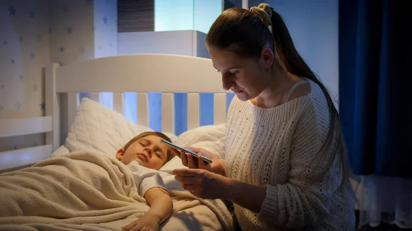 Jovem mãe preocupada chamando médico por telefone à noite. Conceito de doença infantil, doença e cuidado dos pais — Fotografia de Stock