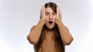 Şok olmuş ve şaşırmış bir kadın kafasını tutup kameraya bakıyor. Şok ve olumsuz duygular