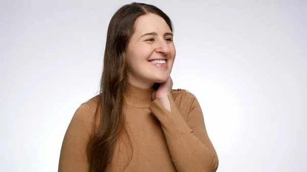 Studio porträtt av leende ung kvinna ler och tittar åt sidan — Stockfoto