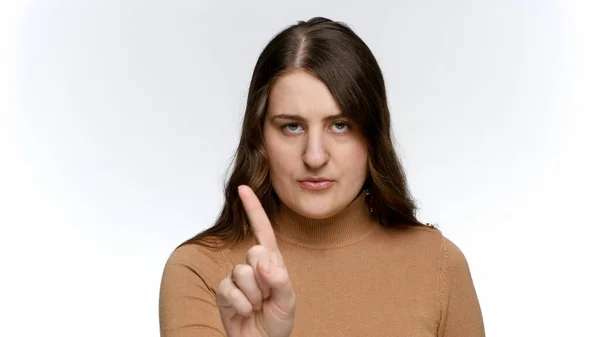 Porträtt av en ung kvinna som säger nej genom att skaka på pekfingret. Begreppet förbud, förbud och tabu. — Stockfoto