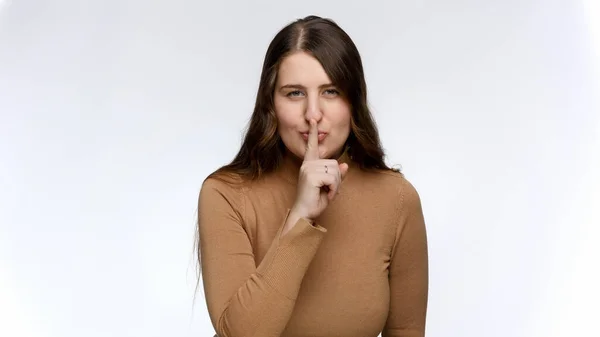 Portrait of smiling woman flirting and putting finger at lips. Concept of keeping secret and silence — Stock Photo, Image