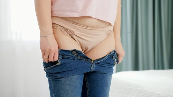 Giovane donna che indossa jeans stretti e non riesce a fissarli. Concetto di sovrappeso, obesità femminile, problemi di dieta e sovrappeso — Foto Stock