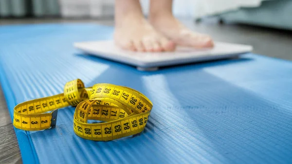 Penutup dari wanita bertelanjang kaki menimbang pada skala pada tikar kebugaran setelah melakukan olahraga atau kebugaran. Konsep diet, kehilangan berat badan dan gaya hidup sehat. — Stok Foto