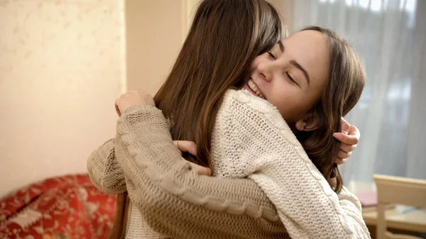 Gelukkig vrolijke meisjes knuffelen en omarmen na ontmoeting in huis — Stockfoto