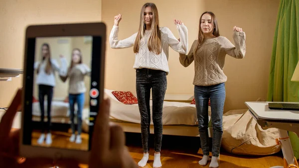 Spela in video på smartphone av två tonårstjejer som dansar för att posta på internet. Modern kommunikation, sociala medier och prylar — Stockfoto