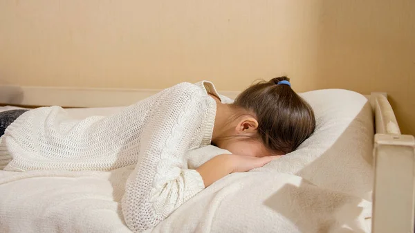Beautiful teenage girl jumping on bed and crying in pillow. Teenager depression and social problems — Stock Photo, Image