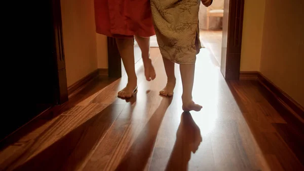 Miembros de la familia en toallas y albornoces caminando desde el dormitorio hasta el baño o la piscina por la mañana. Concepto de familia viviendo en casa grande o de vacaciones — Foto de Stock