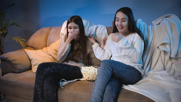 Dos chicas riendo mientras ven comedia en la televisión por la noche — Foto de Stock