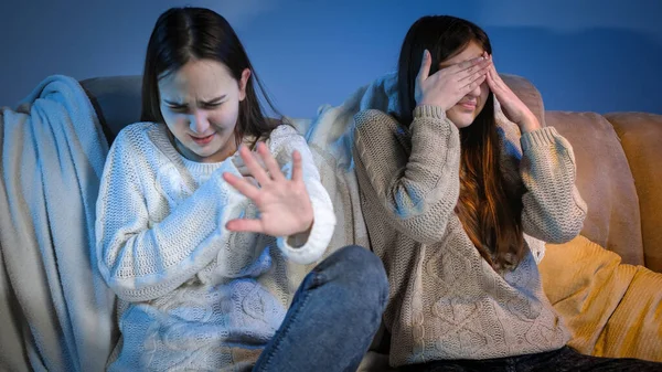 Dos chicas viendo programas de televisión espeluznantes o malos y sintiéndose asquerosas — Foto de Stock