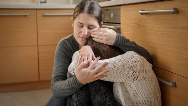 Fiatal anya ül a síró lánya mellett és vigasztalja. Mentális problémák és a tizenévesek depressziója — Stock Fotó