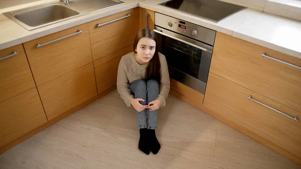 Pov záběr dospívající dívky sedící na podlaze a skrývající se před agresí a násilím. Pojetí domácího násilí a rodinné agrese. — Stock fotografie
