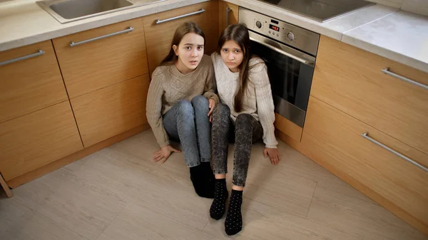 Duas meninas com medo de bater pelo pai sentado no chão e chorando. Conceito de violência doméstica e agressão familiar. — Fotografia de Stock