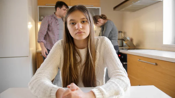 Remaja gadis melihat di kamera sementara orang tua berdebat dan memiliki konflik di dapur. Kekerasan keluarga, konflik dan masalah hubungan — Stok Foto