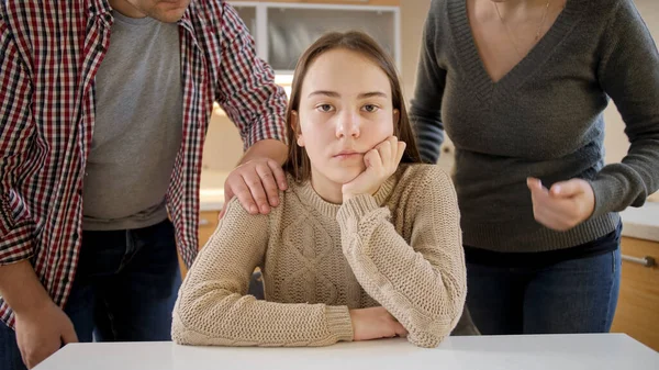 Chica adolescente mirando a la cámara e ignorando a los padres gritándole. Violencia familiar, conflictos y problemas de relación — Foto de Stock