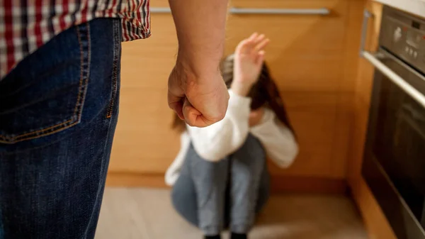 Злой отец угрожал и бил плачущую дочь кулаком. Концепция домашнего насилия, насилия со стороны родителей и семейной агрессии. — стоковое фото