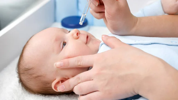 Curar al bebé con secreción nasal usando medicamentos en gotitas de secreción nasal. Concepto de salud infantil, cuidado del bebé y atención médica. — Foto de Stock