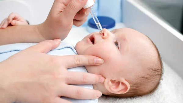 Närbild av läkare som ger coronavirus vaccin till nyfödda barn från eyedropper på sjukhus — Stockfoto