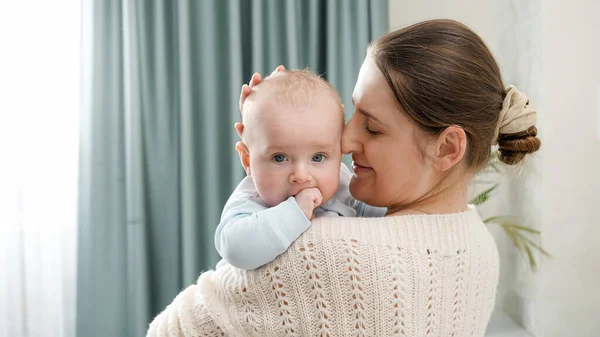 Beautiful smiling woman stroking her little baby son at bedroom. Concept of family happiness and child development — Stock Photo, Image