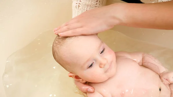 Primer plano de la madre lavando la cabeza del bebé con champú en el baño — Foto de Stock