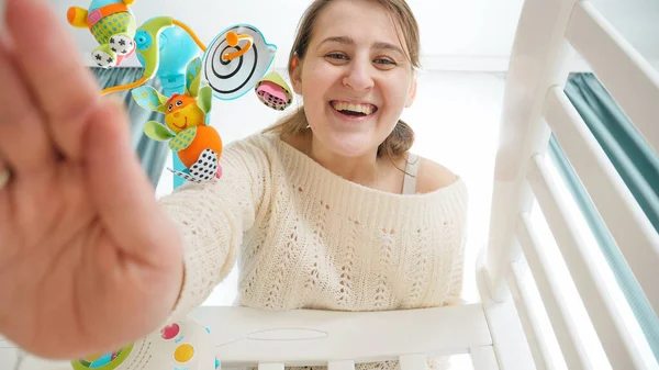 POV da mãe acariciando suavemente e acariciando seu bebê deitado em berço de madeira. Conceito de parentalidade, felicidade familiar e desenvolvimento do bebê. — Fotografia de Stock