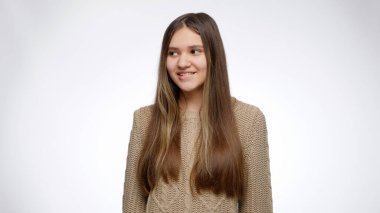 Gülümseyen kızın komik bir portresi. Yüzler yapıp beyaz stüdyo geçmişinde flört ediyor..