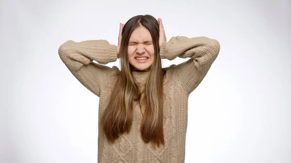 Ung flicka känner sig irriterad av högt ljud och lider av huvudvärk stänga öronen med händerna — Stockfoto