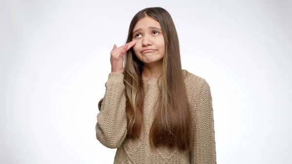 Porträt von Teenager-Mädchen wischt sich Tränen und schüttelt den Kopf über weißen Studiohintergrund. — Stockfoto