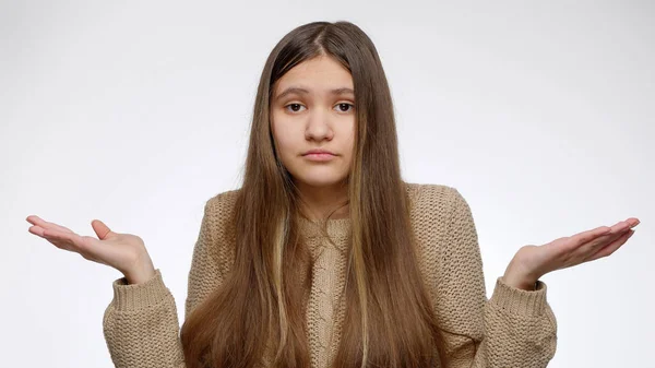 Zdezorientowana lub zdziwiona dziewczyna zgubiła coś i szukała tego na białym tle studia. — Zdjęcie stockowe