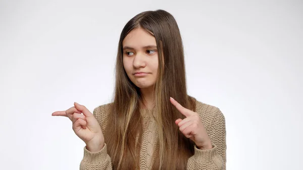 Chica sonriente anunciando algo sobre fondo blanco y señalando con el dedo. Coloca tu producto u objeto. Plantilla publicitaria — Foto de Stock