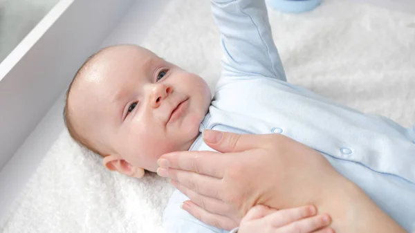 Mano de las madres tocando suavemente su cara de bebé. Concepto de cuidado del bebé, crianza y felicidad familiar. — Foto de Stock