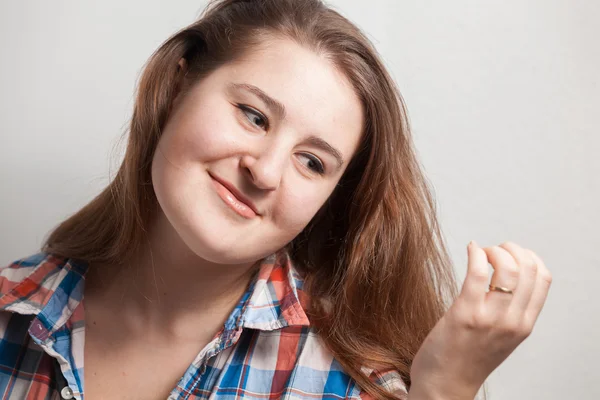 Schöne brünette Frau im karierten Hemd, die ihr Haar hält — Stockfoto